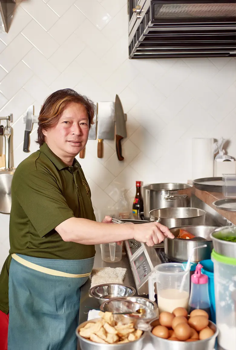 Chef Don Lim preparing food and stirring pot with crabs inside